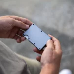 Person Holding Gray Ultra-Slim Metal Wallet