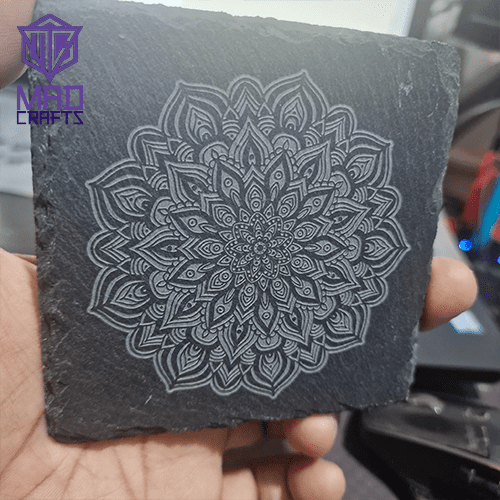 Intricate mandala design engraved on a natural slate coaster